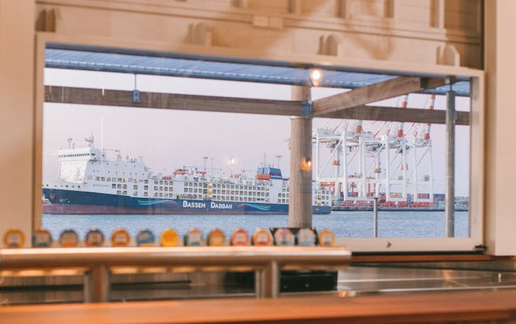 a bar looking out to the port with a container ship