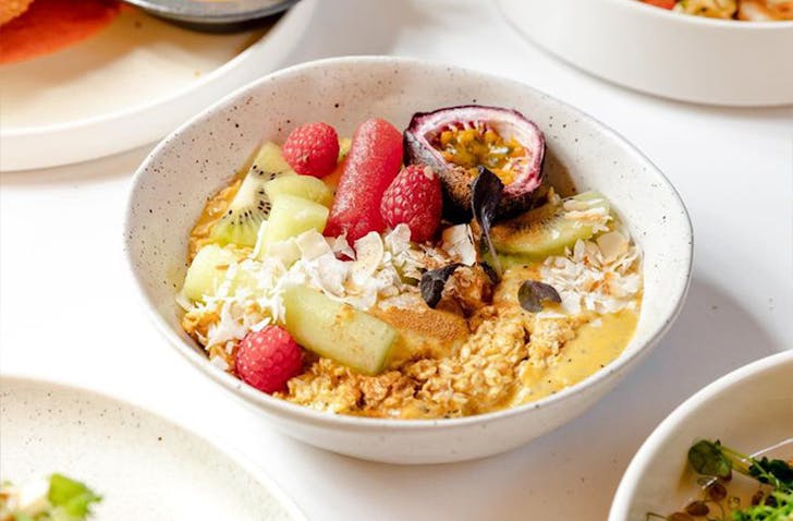 A yoghurt bowl topped with fresh fruit and granola.