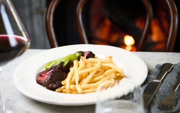 A plate of steak frites with a glass of wine at one of the best restaurants in Richmond. 