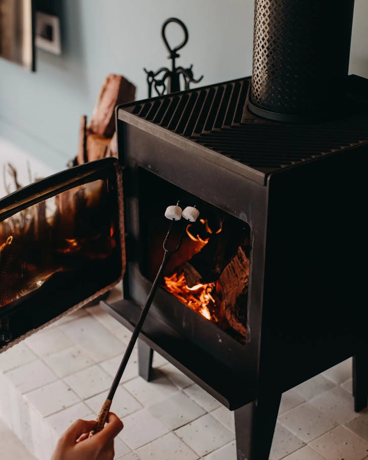 Someone toasting marshmallows over a fireplace in a WA Airbnb