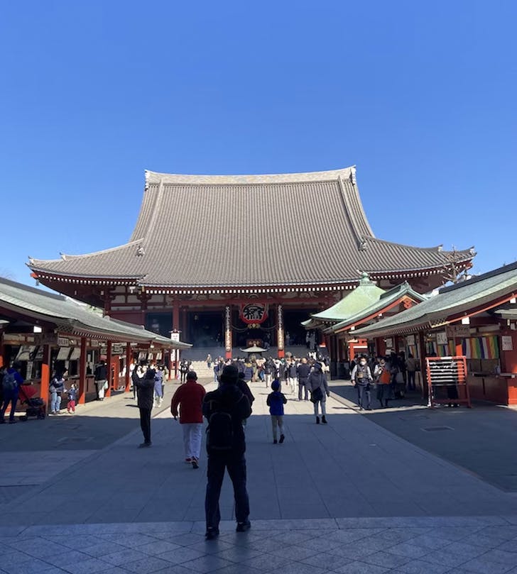 people standing in front of a japanese temple